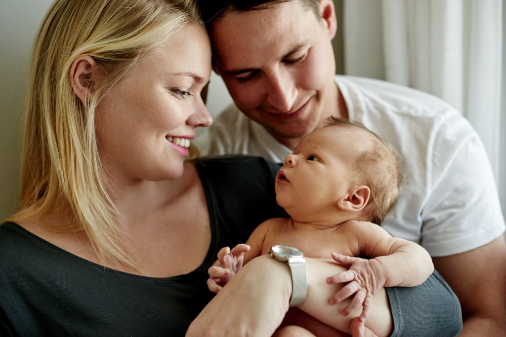 Young married couple holding their newborn baby