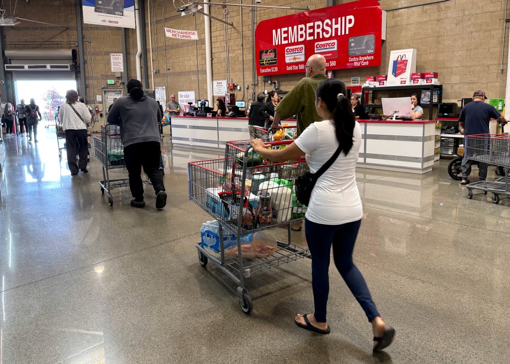 Customers walk by the membership counter at a Costco store in Richmond, California, where the announcement of a membership fee increase was made