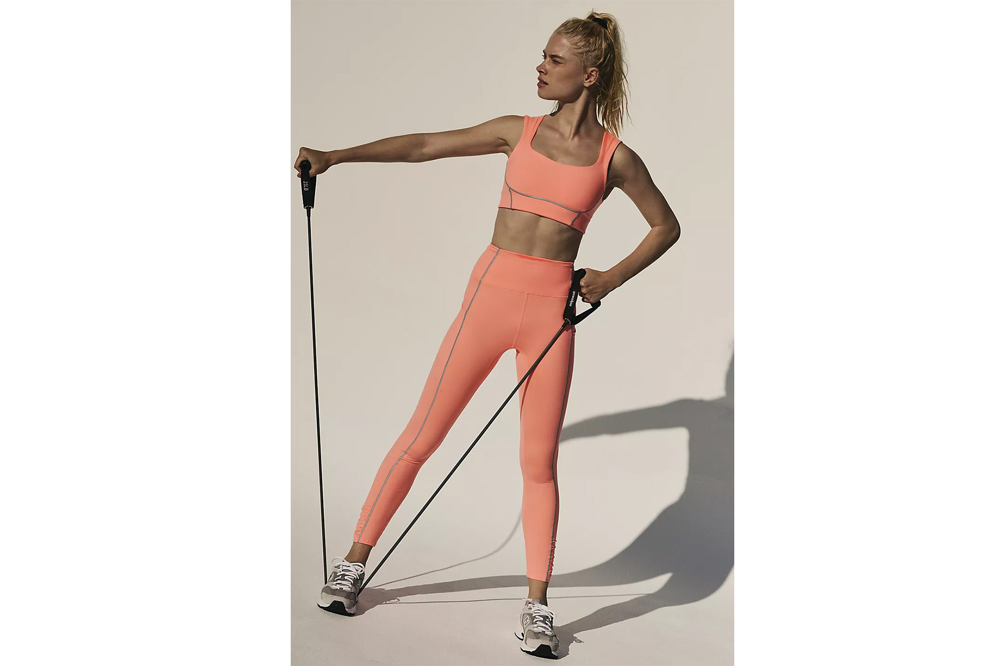 A model in peach leggings and a matching sports bra