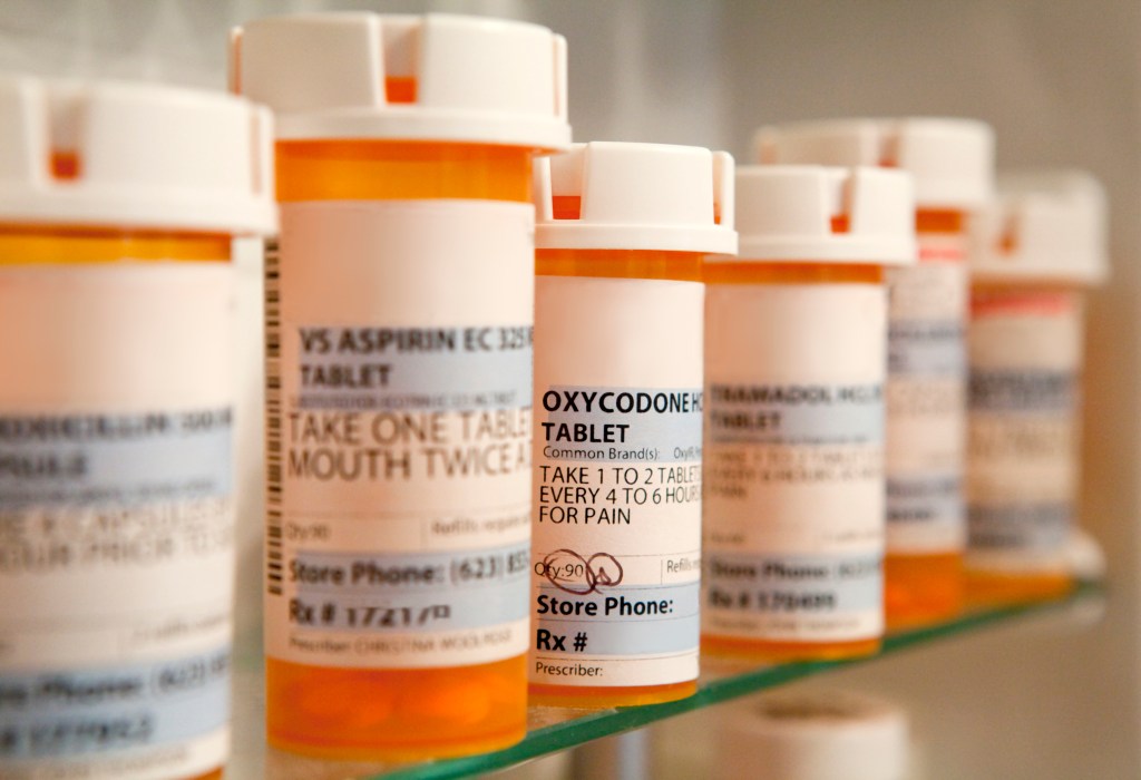 A group of prescription bottles on a shelf