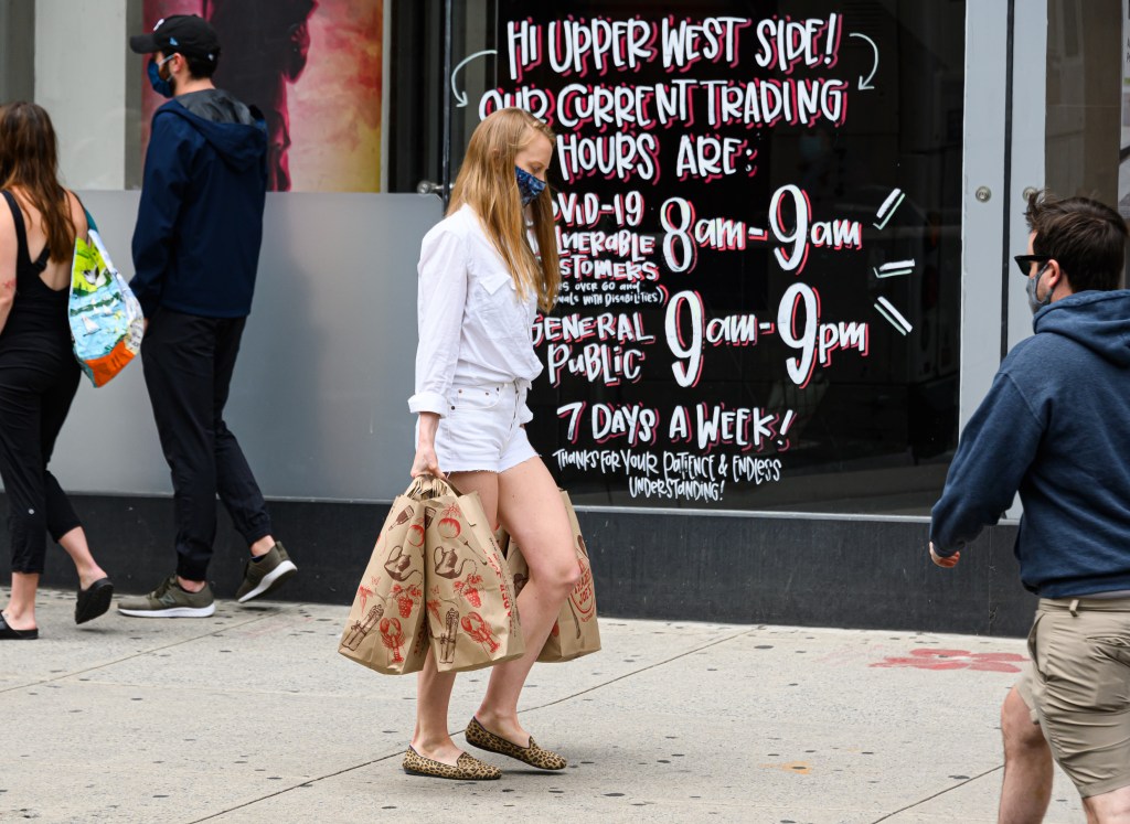 Person wearing a protective mask and carrying grocery bags outside Trader Joe's in New York City during the Coronavirus pandemic